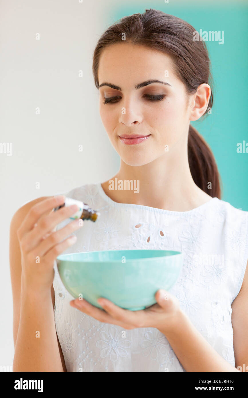 Donna che utilizza olio essenziale. Foto Stock