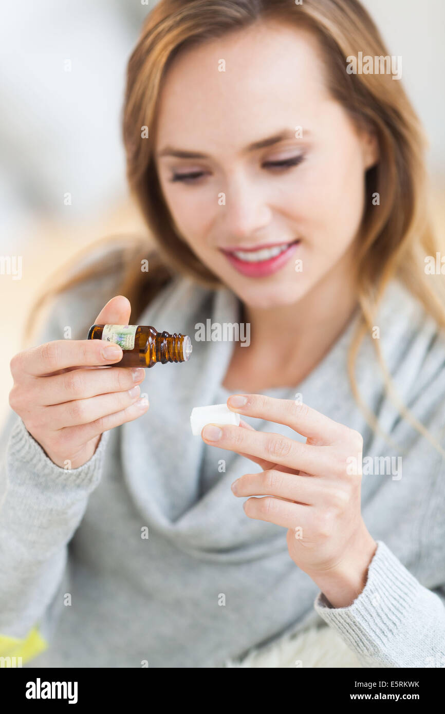 Donna di applicare olio essenziale sullo zucchero. Foto Stock