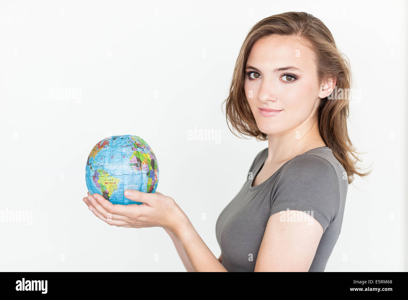 Donna che mantiene una mappa del mondo. Foto Stock