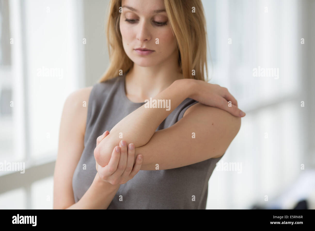 La donna che soffre di un dolore al gomito a gomito del tennista). Foto Stock