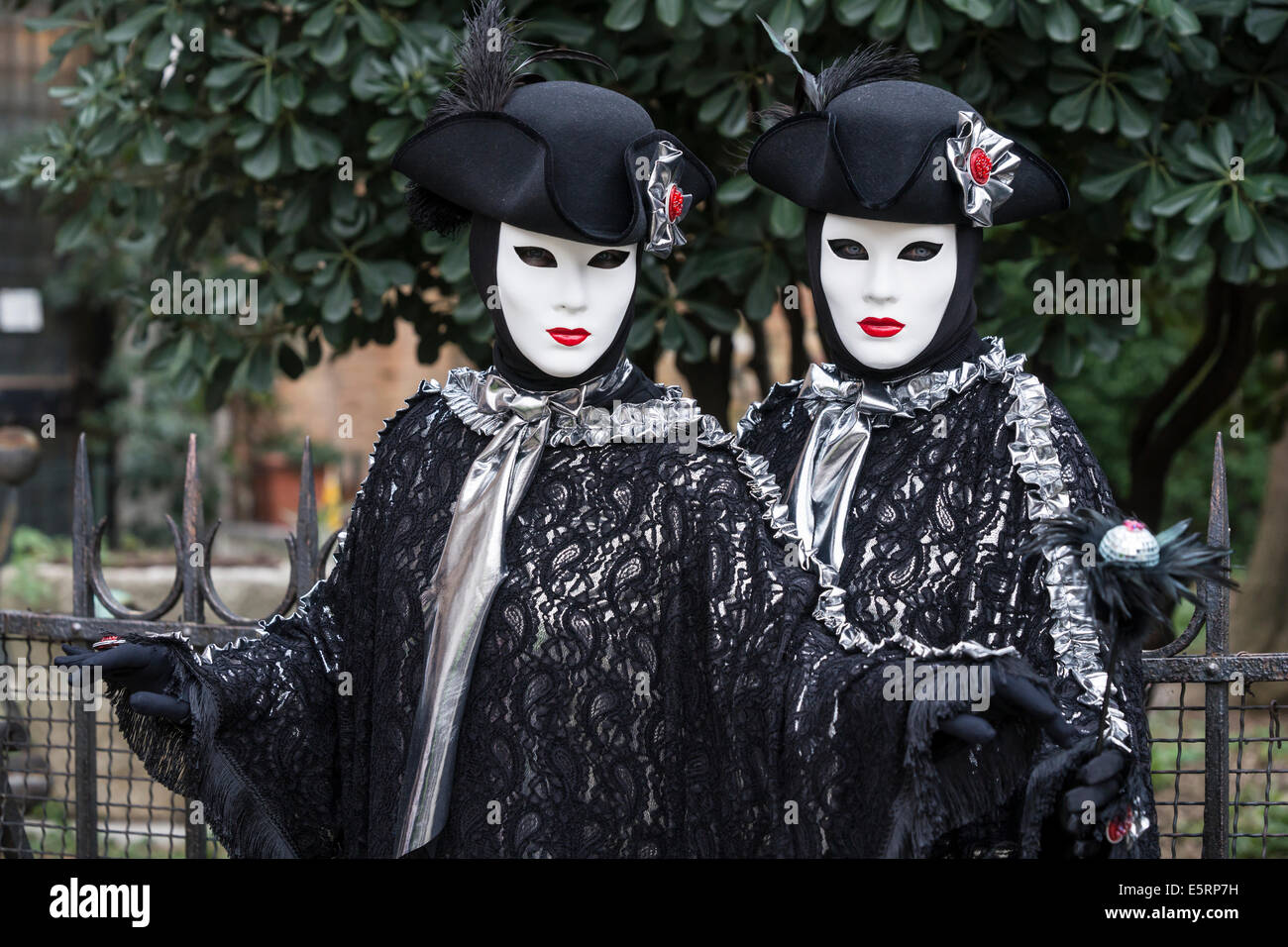 2 Donne in identiche stilizzata costumi settecenteschi di nero con argento dalla chiesa di San Zaccaria durante il Carnevale di Venezia. Foto Stock