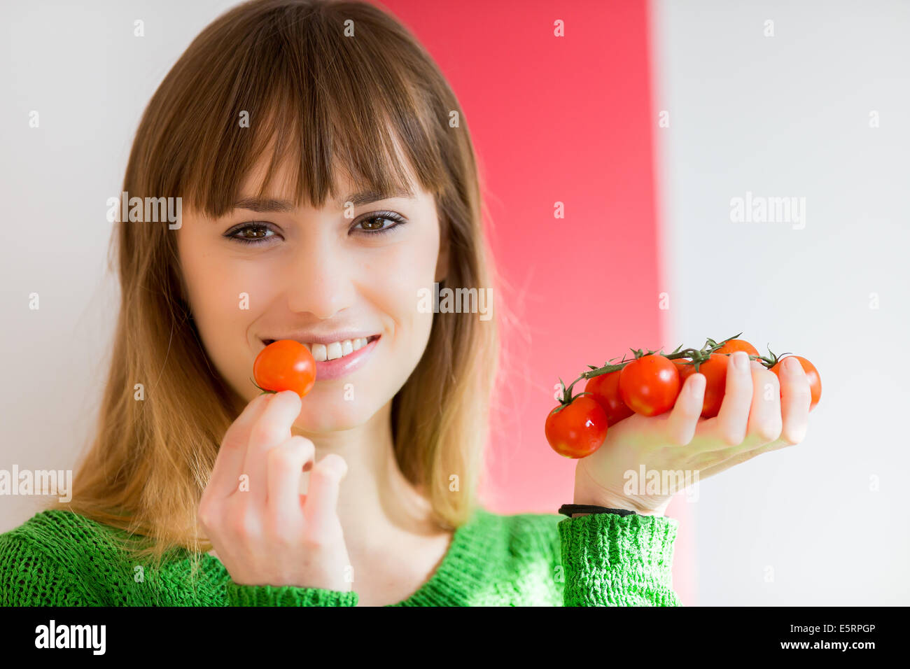 Donna di mangiare i pomodori. Foto Stock