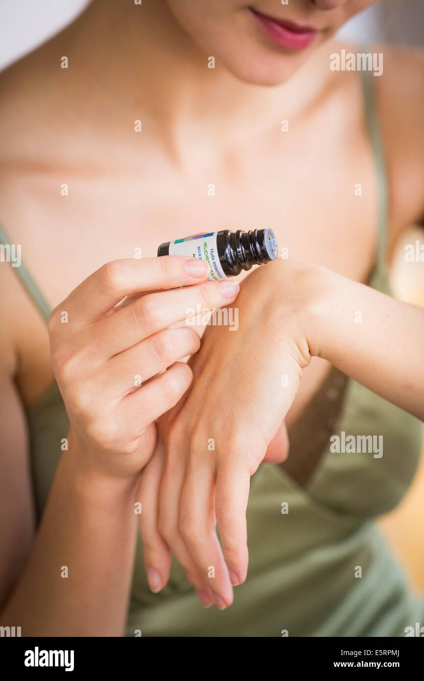 Donna l'applicazione di olio essenziale sulla sua pelle. Foto Stock