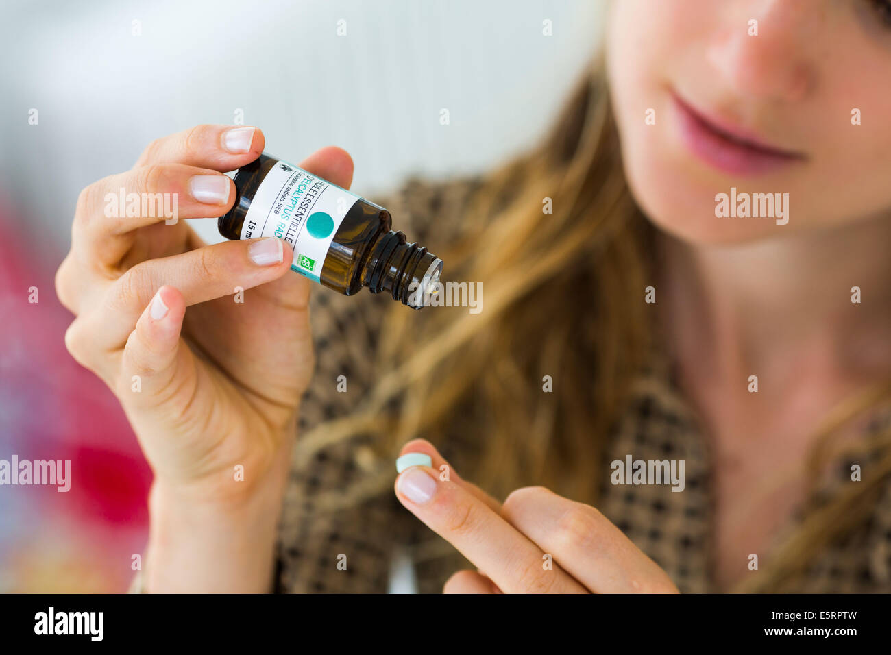 Donna l'applicazione di olio essenziale su una pillola di folle. Foto Stock