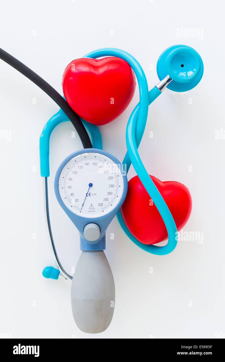 Uno stetoscopio in plastica che circonda il cuore e il tensiometro. Foto Stock
