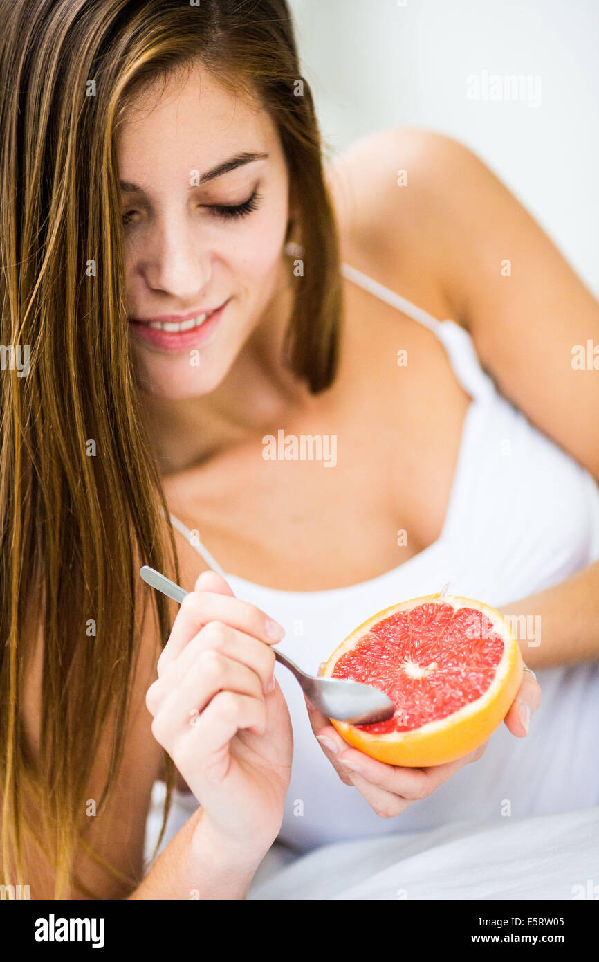 Donna di mangiare un pompelmo. Foto Stock