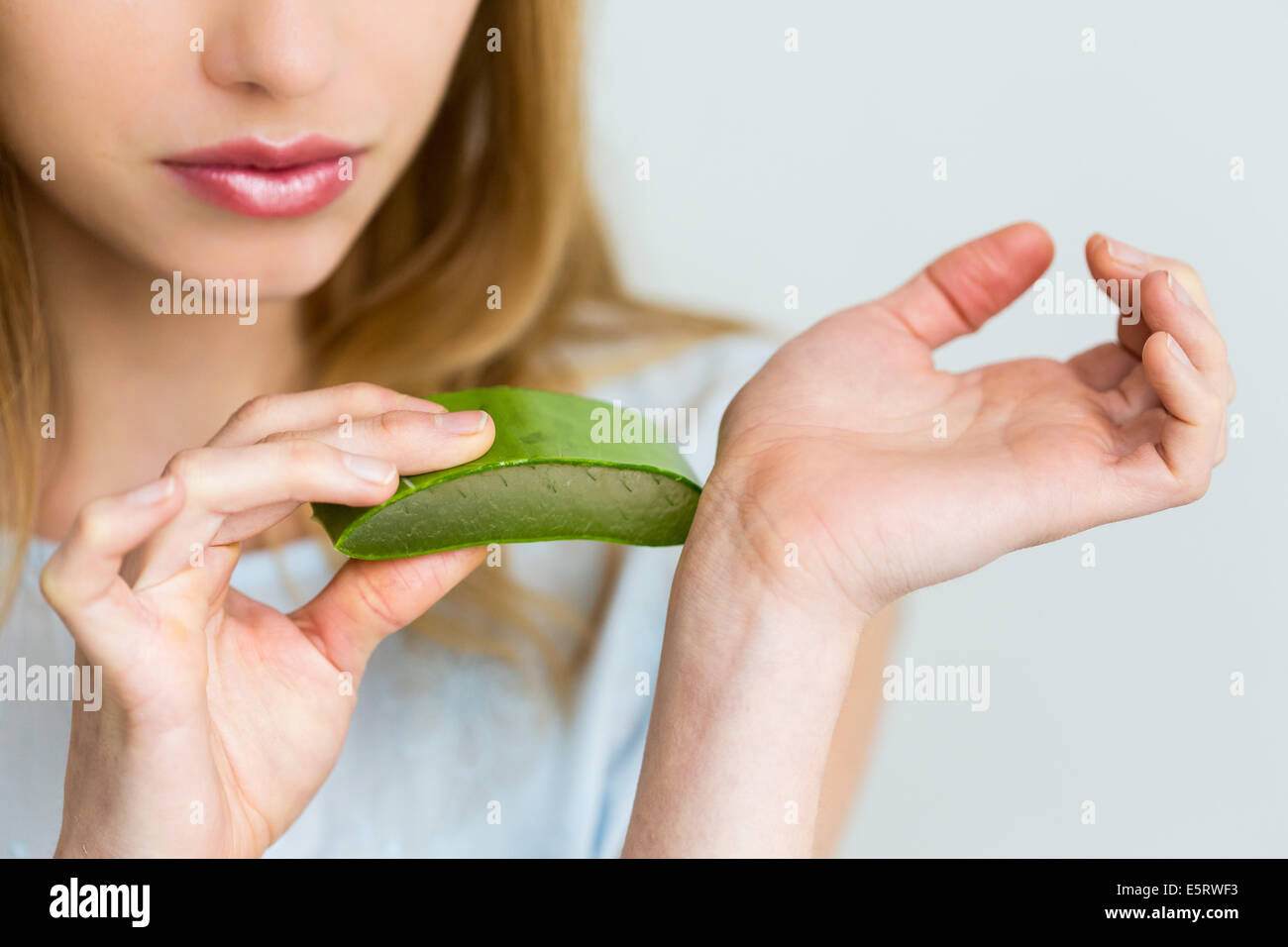 Donna applicando una foglia di aloe vera sulla pelle Foto stock - Alamy