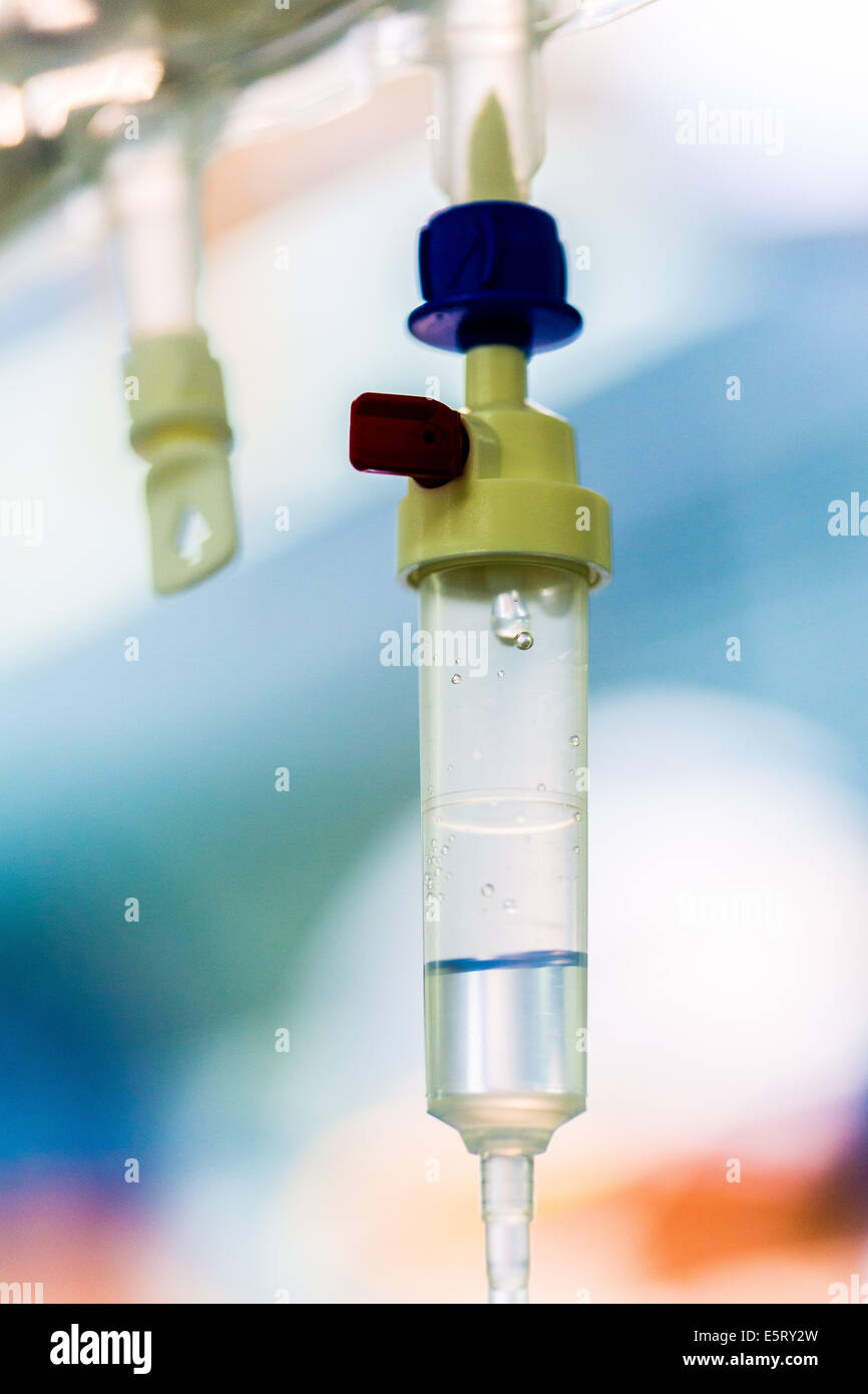 Close-up della camera di gocciolamento di una somministrazione endovenosa (IV) drip attaccato ad un paziente che subisce un intervento chirurgico. Foto Stock