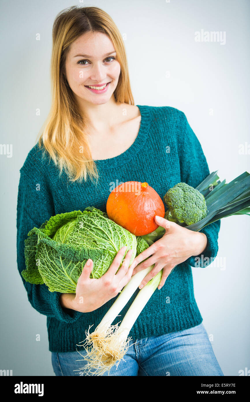 Donna che mantiene le verdure nelle sue braccia. Foto Stock