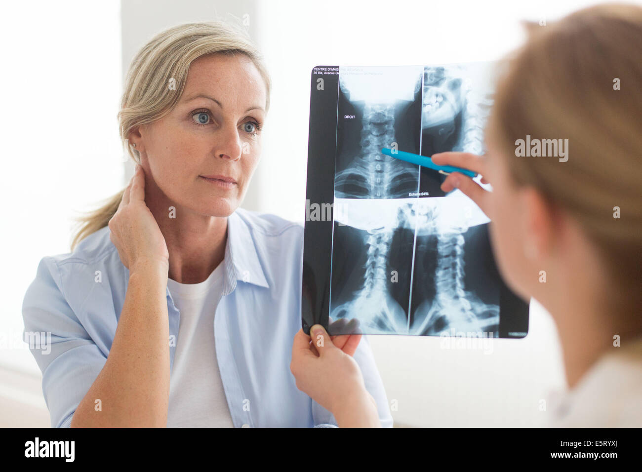 Medico guardando un della colonna vertebrale cervicale a raggi x del suo paziente. Foto Stock