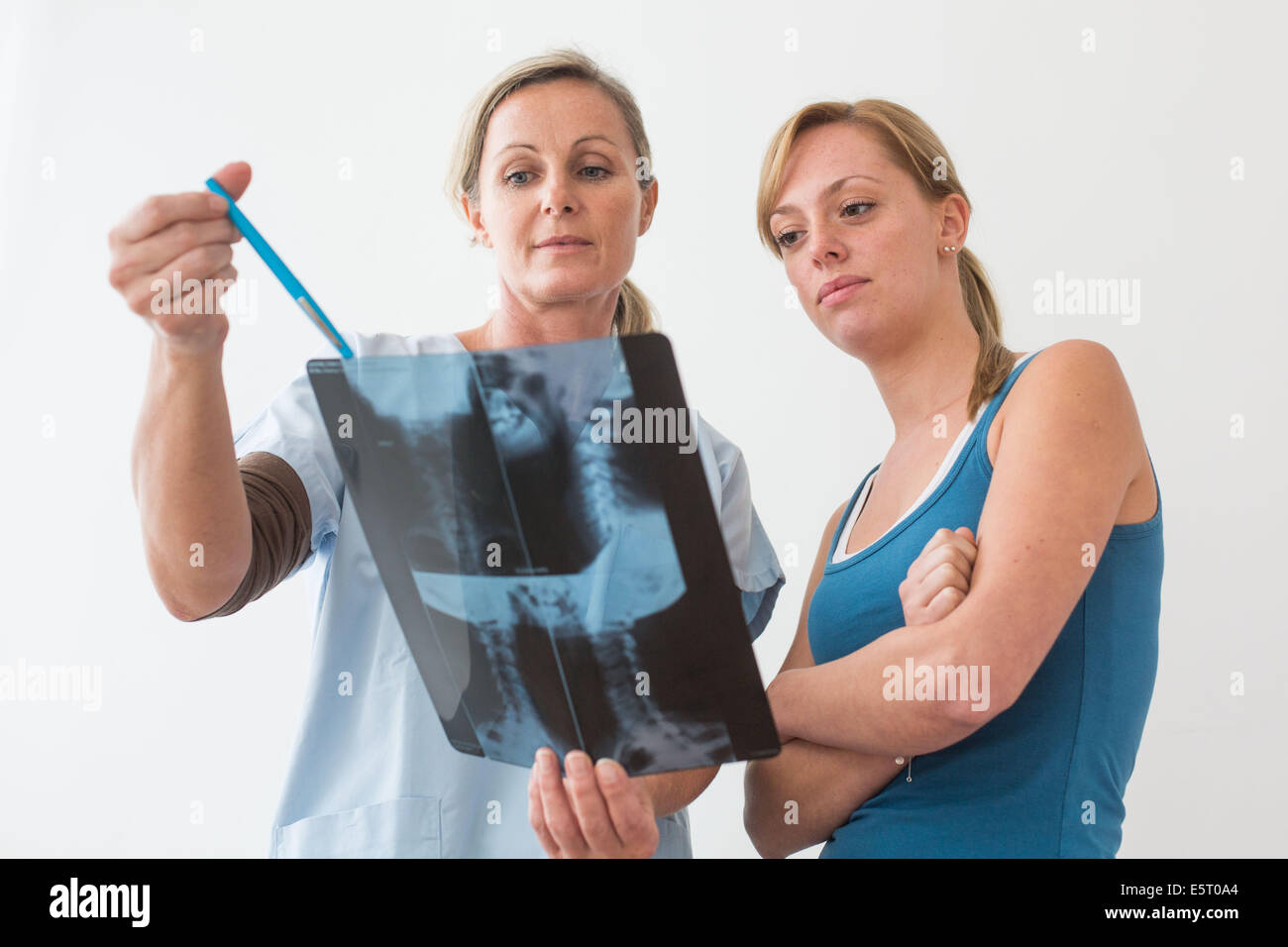 Medico guardando un della colonna vertebrale cervicale a raggi x del suo paziente. Foto Stock
