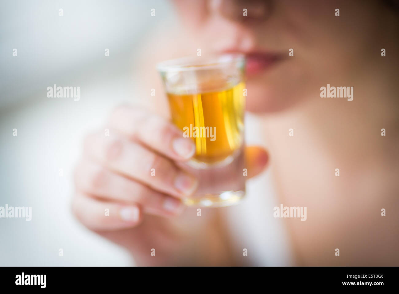 Donna di bere un alcool shot. Foto Stock