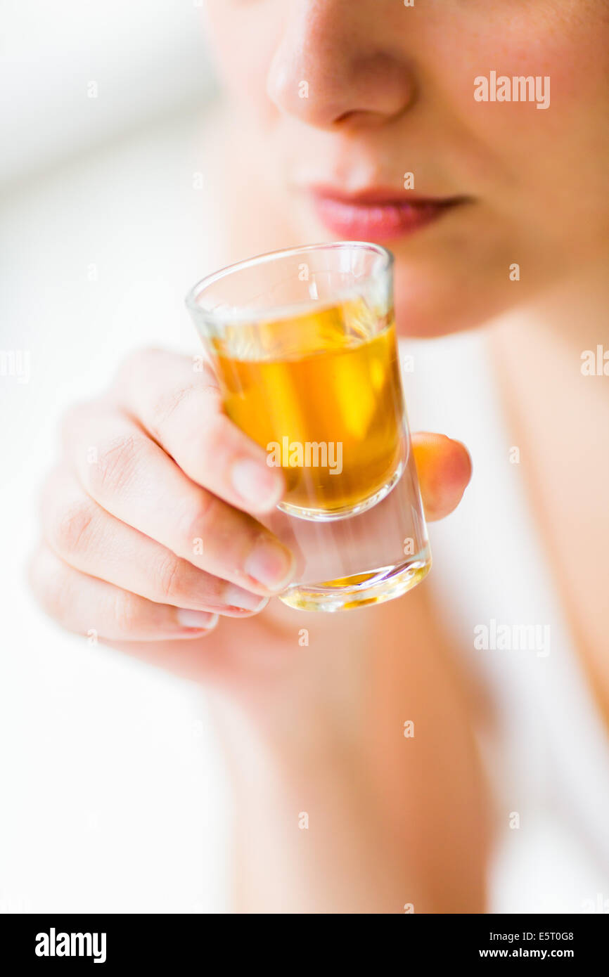 Donna di bere un alcool shot. Foto Stock