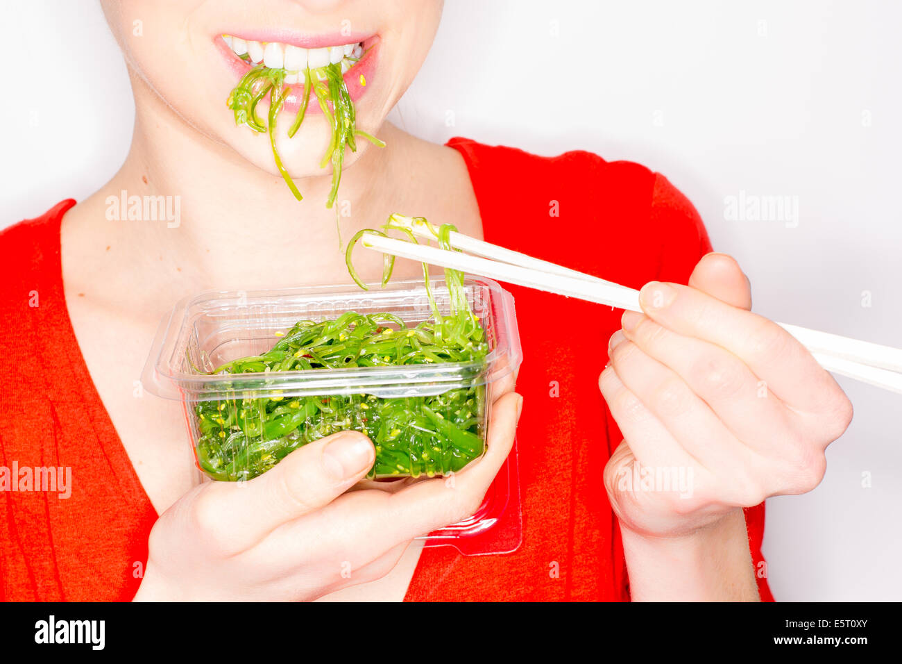 Donna di mangiare alghe commestibili. Foto Stock