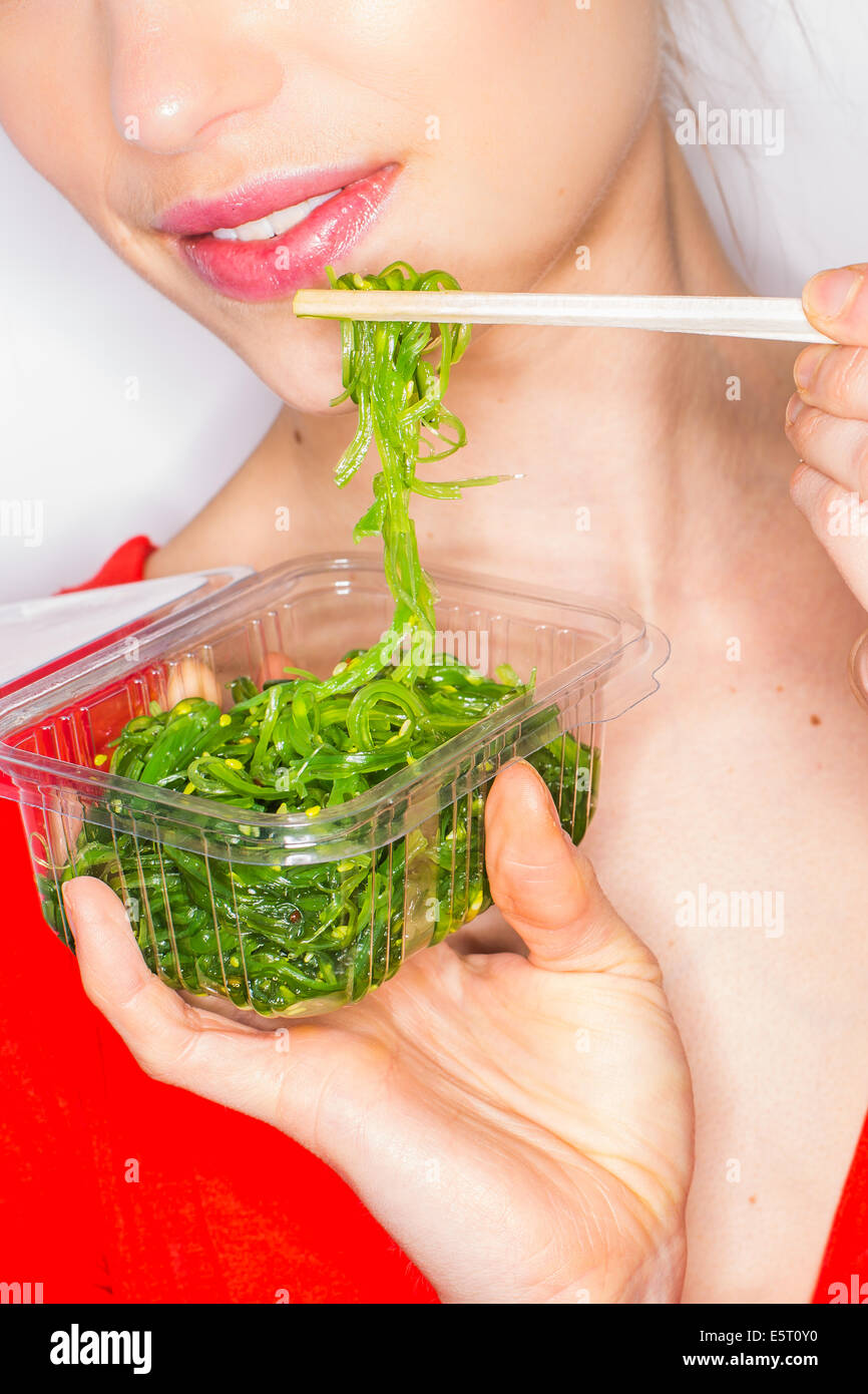 Donna di mangiare alghe commestibili. Foto Stock