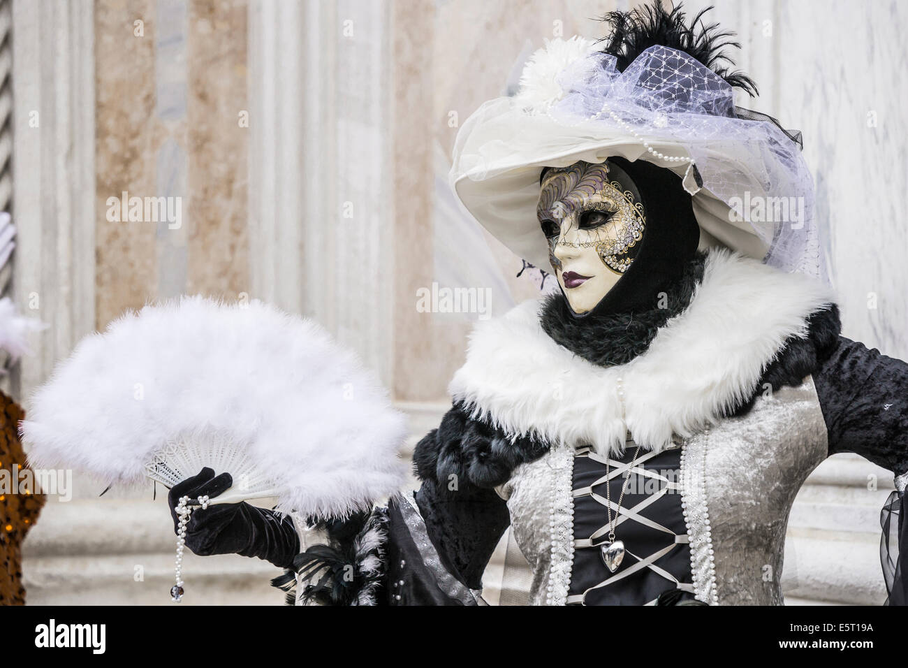 Donna in Nero elaborate con il costume bianco e feathered fan di fronte la  chiesa di san Zaccaria durante il carnevale di Venezia Foto stock - Alamy