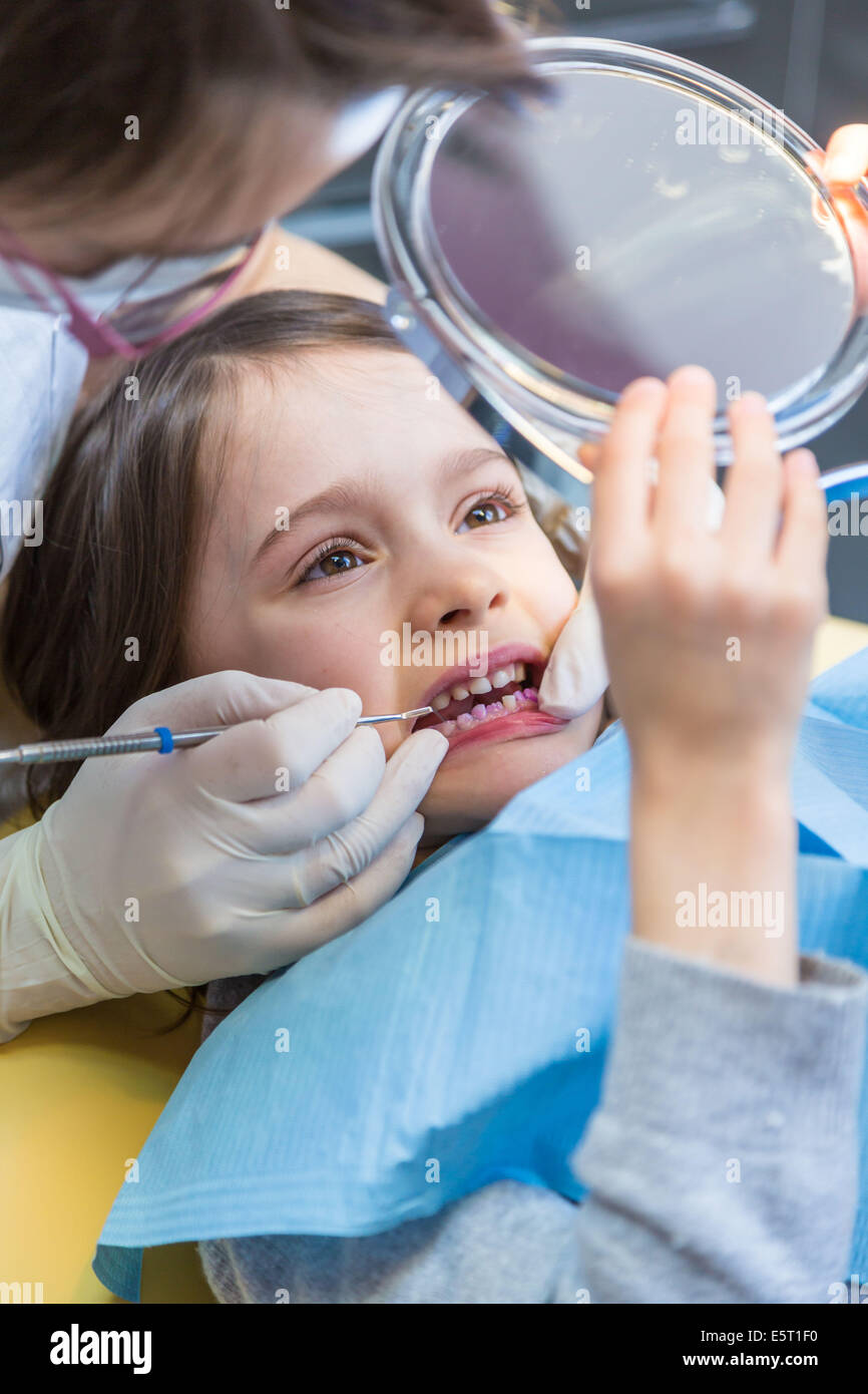 6 anno vecchia ragazza presso il dentista, l'applicazione del gel di fluoruro utilizzati nella prevenzione della carie dentaria. Foto Stock