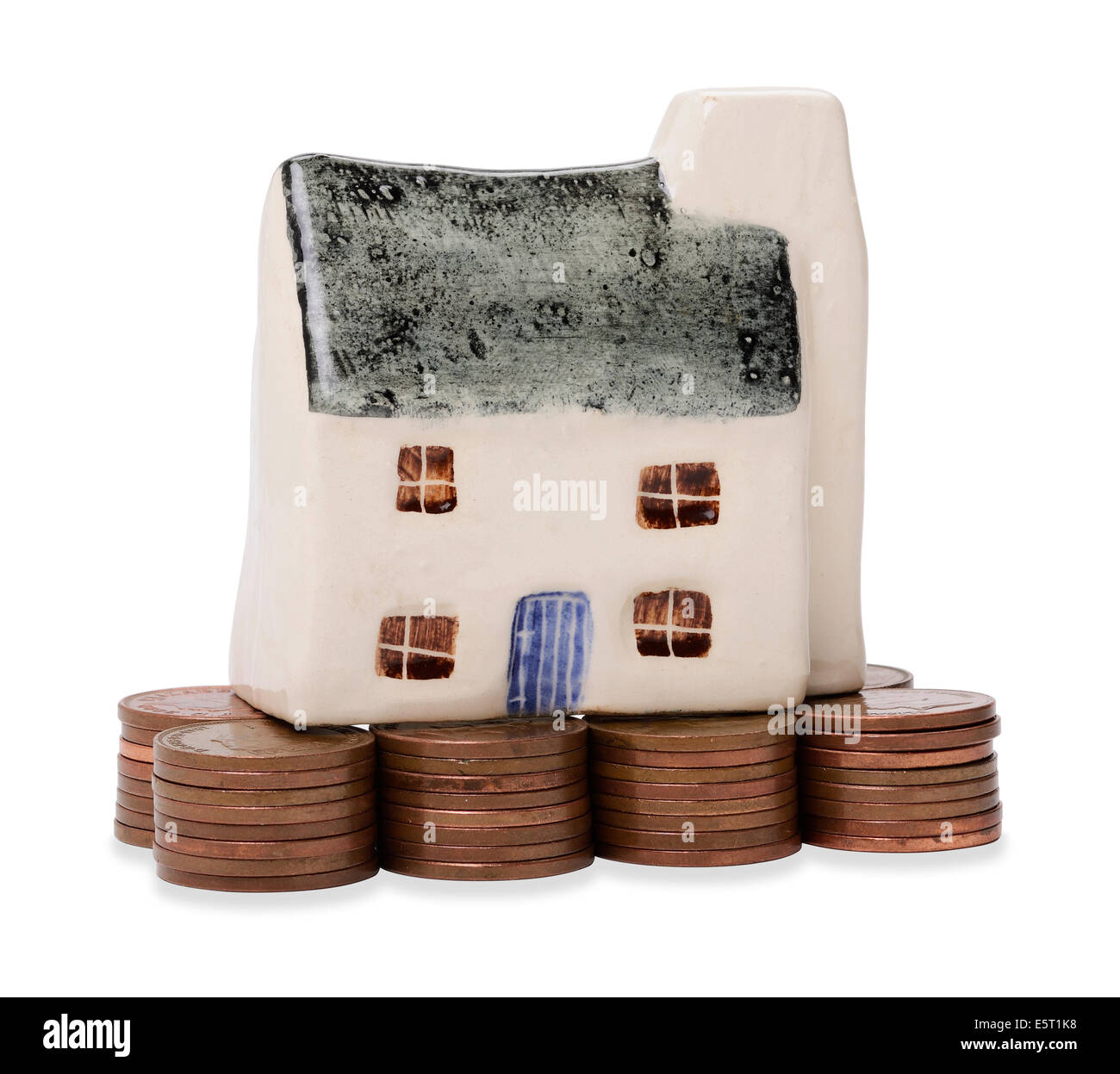Modello in miniatura casa su una pila di monete Foto Stock