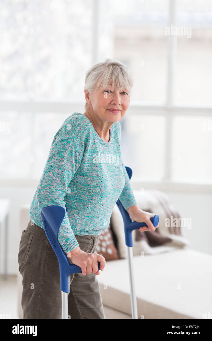 Donna anziana camminando con le stampelle. Foto Stock