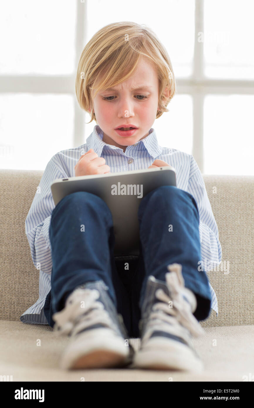 Ragazzo di 7 anni utilizzando computer tablet. Foto Stock