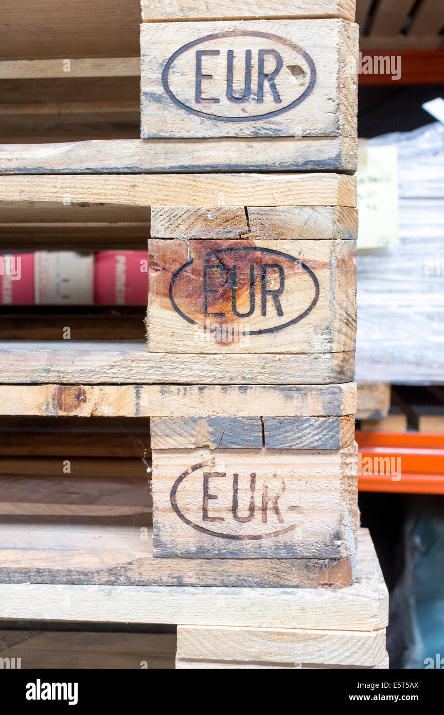 Blocchi di legno portante il EUR simbolo Euro su una pila di pallet Euro Foto Stock