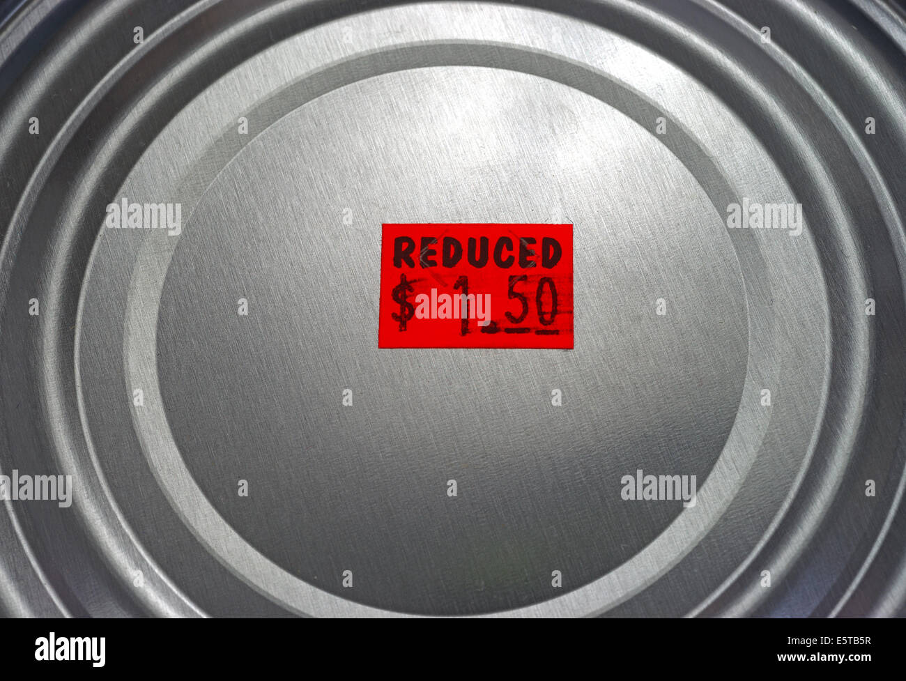 Chiudere la vista del coperchio di un barattolo di conserve alimentari con un rosso brillante prezzo ridotto adesivo. Foto Stock