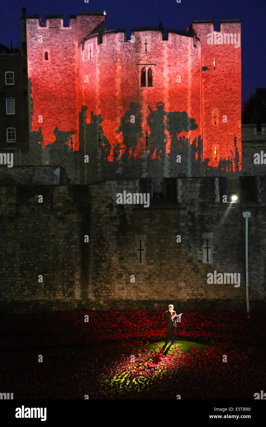 Londra, Regno Unito. 5 agosto 2014. Tim Pigott-Smith all apertura del sangue spazzata di terre e mari di Red artwork da Paolo Cummins presso la Torre di Londra. 888,246 papaveri in ceramica, ciascuno il papavero rappresenta un britannico o coloniale fatalità militare durante la guerra, andrà a riempire il fossato da novembre 11th. Per l'apertura, battlefield immagini proiettate nella torre centrale mentre Tim Pigott-Smith leggere i nomi dei caduti durante una pistola 21 salute. La serata si è conclusa con la riproduzione dell'ultimo post. Credito: Paul Brown/Alamy Live News Foto Stock
