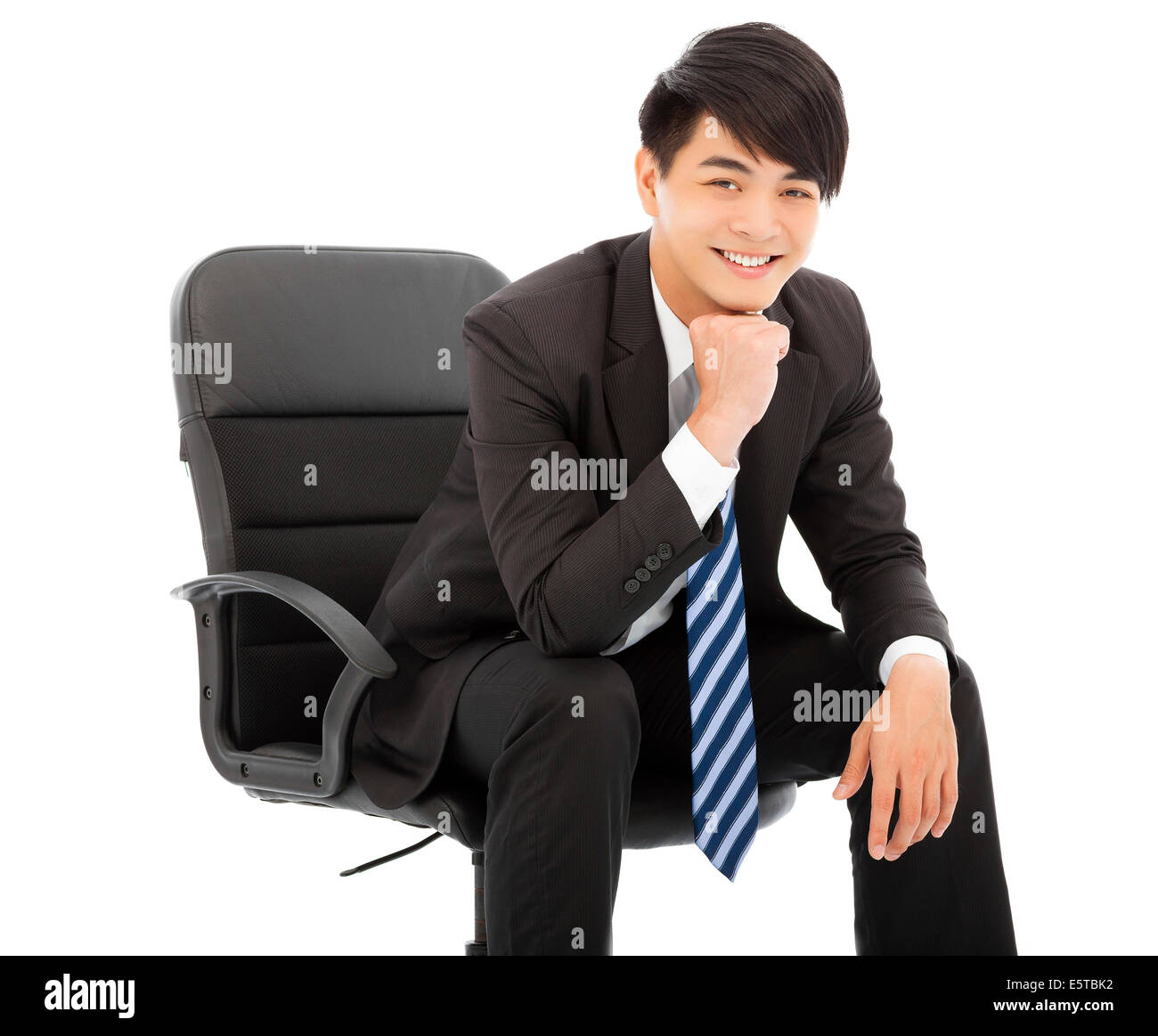 Sorridente imprenditore giovane seduto su una sedia Foto Stock