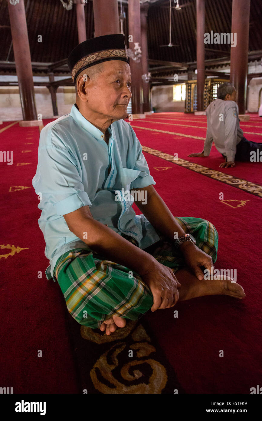 Yogyakarta, Java, Indonesia. Uomo in attesa di mezzogiorno preghiere, la Grande Moschea, Masjid Gedhe Kauman, mid-18th. Secolo. Foto Stock