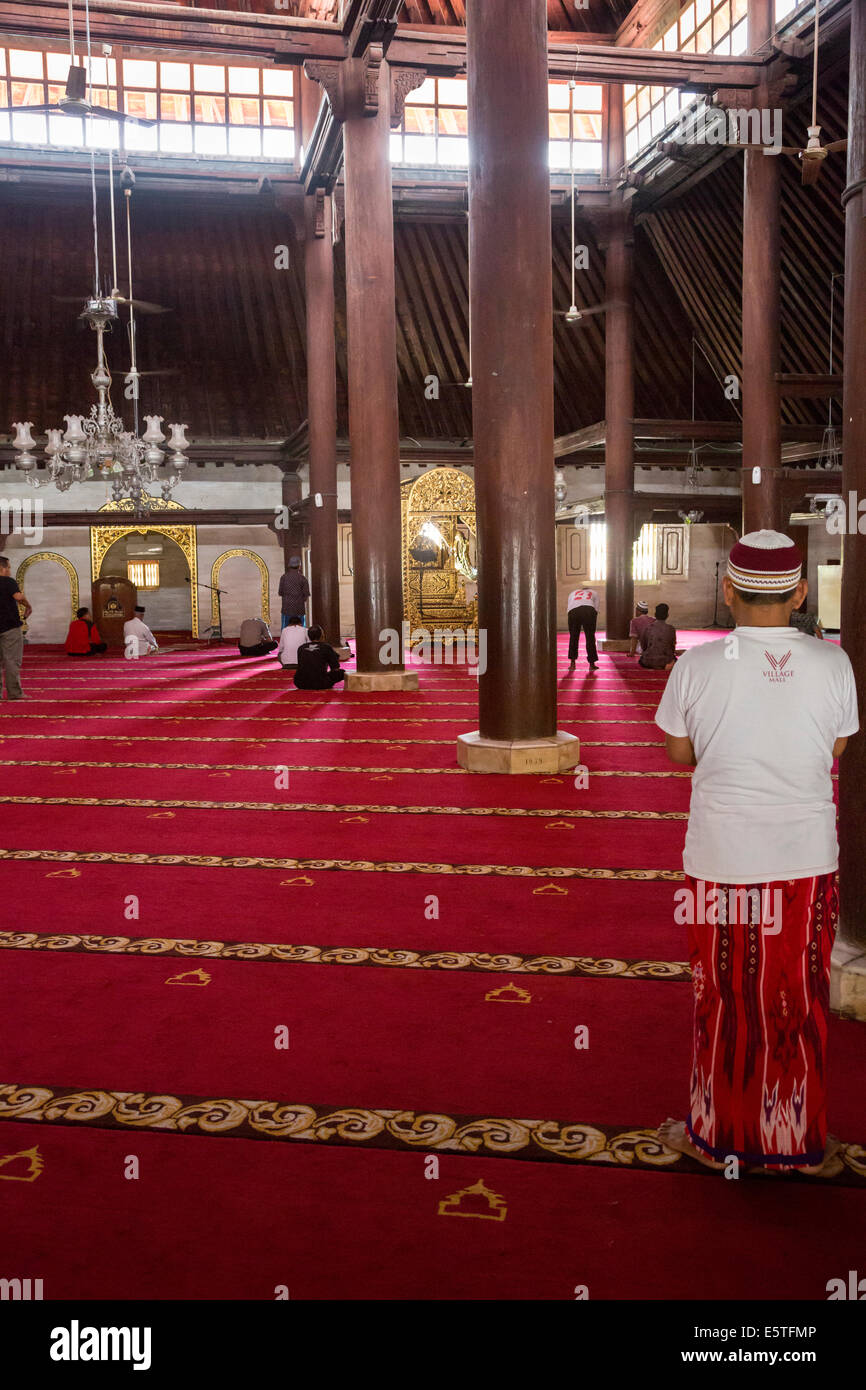 Yogyakarta, Java, Indonesia. Interno della Grande Moschea, Masjid Gedhe Kauman, mid-18th. Secolo. Gli uomini si riuniscono per la preghiera. Foto Stock