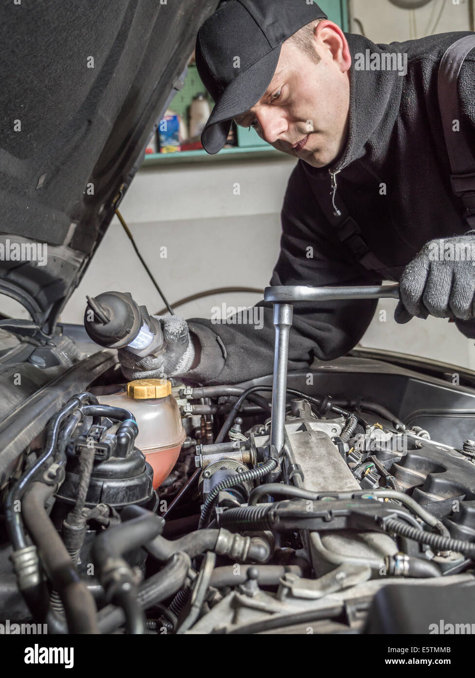 Meccanico automatico di sostituzione delle candele a incandescenza nella vettura motore diesel utilizzando la candela chiave Foto Stock