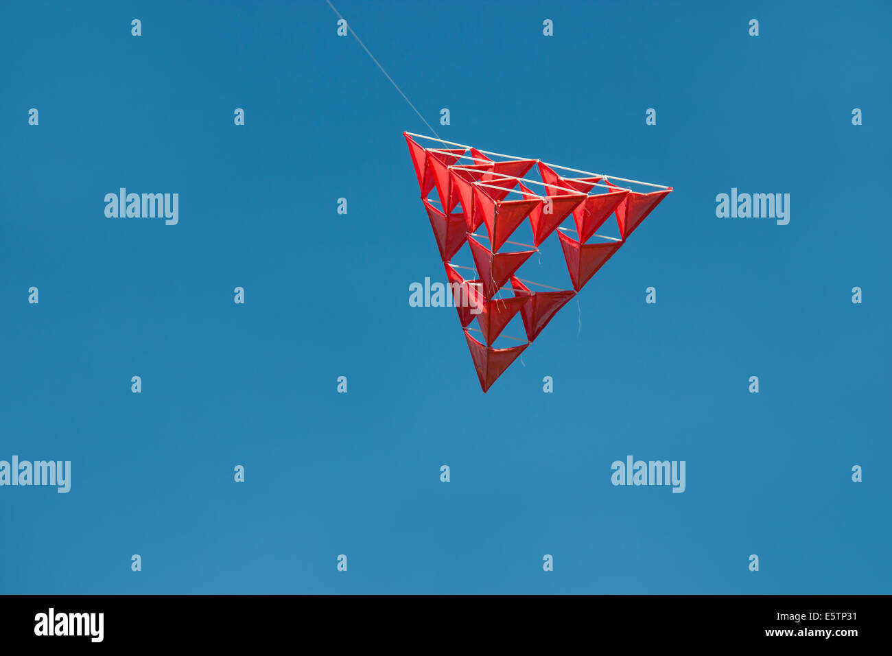 Insolito kite tetraedrico fatti di cannucce, linea e carta volare alto con cielo blu Foto Stock
