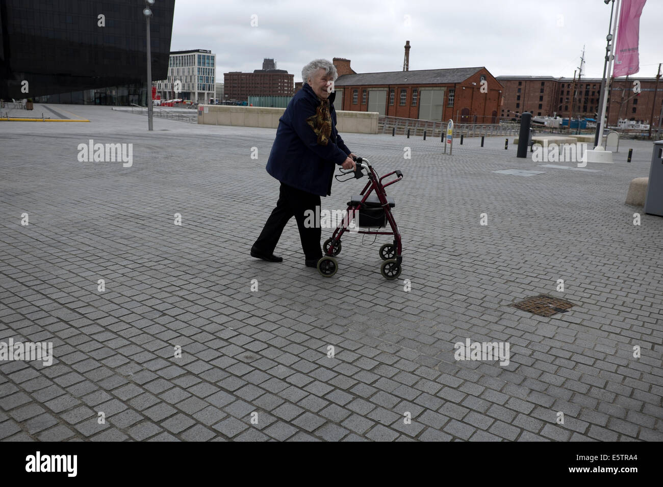 Old Lady Donna con passeggino a ruote a piedi Foto Stock