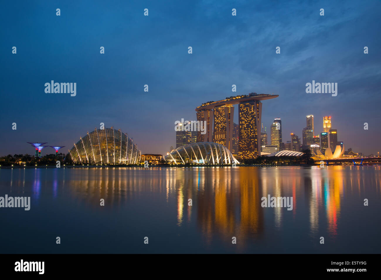 Singapore skyline al tramonto, area di Marina Bay. I punti di riferimento prevalente sull'immagine sono il Marina Bay Sands e giardini della baia Foto Stock