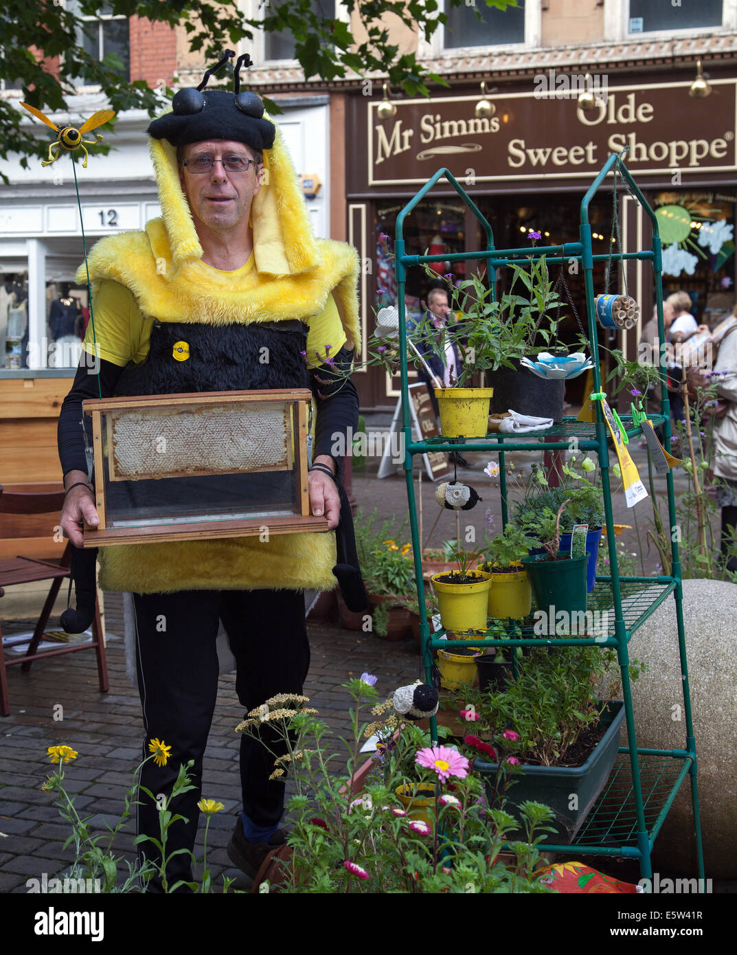 Uomo in costume da ape holidng beehive favo di miele in Manchester, UK  Amici della Terra Pete Abel a scavare la città Deansgate, un annuale urbano  festival di giardinaggio consegnati da Manchester