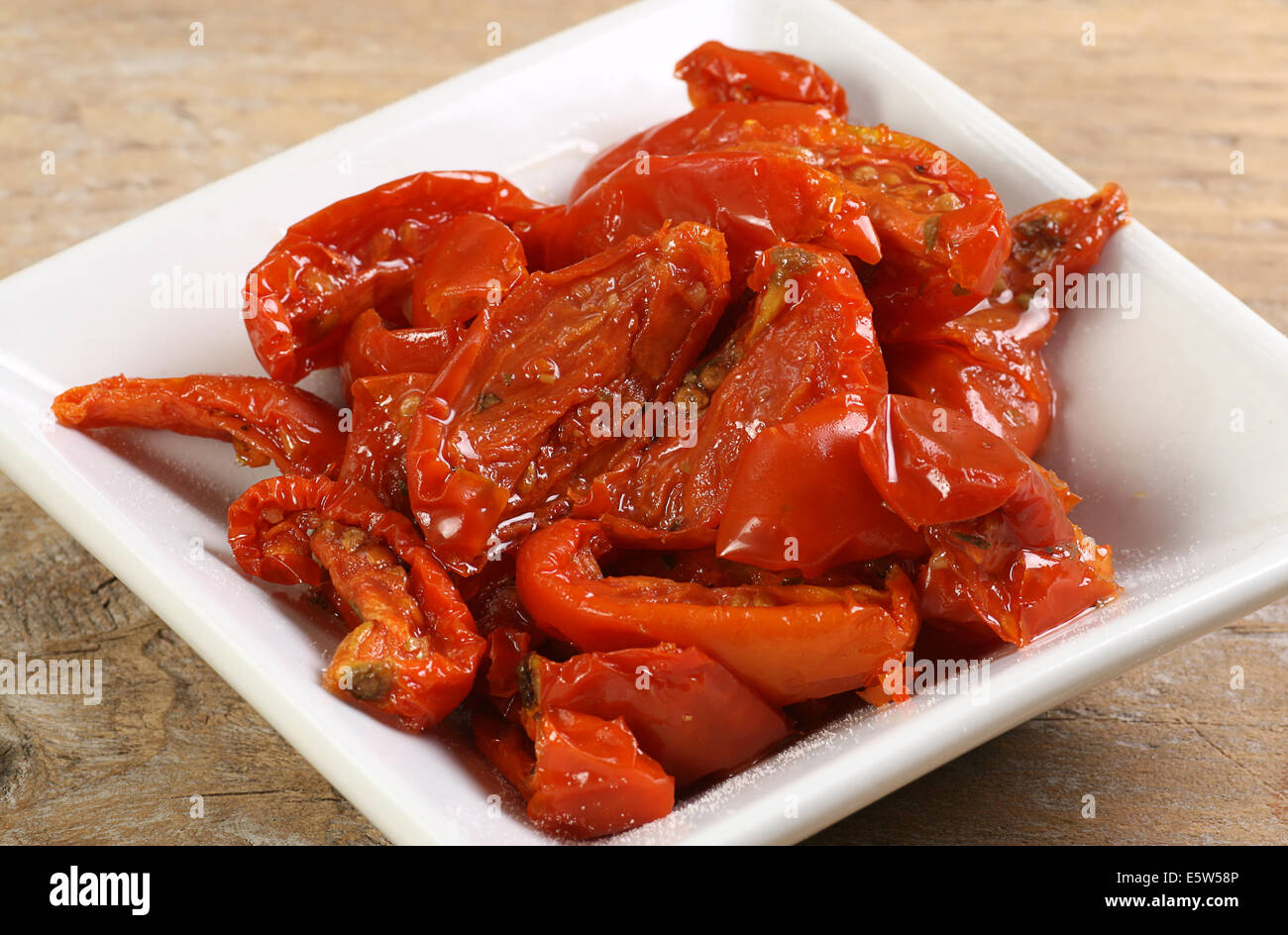 Sun Pomodori secchi conditi con sale marino su un piatto bianco Foto Stock
