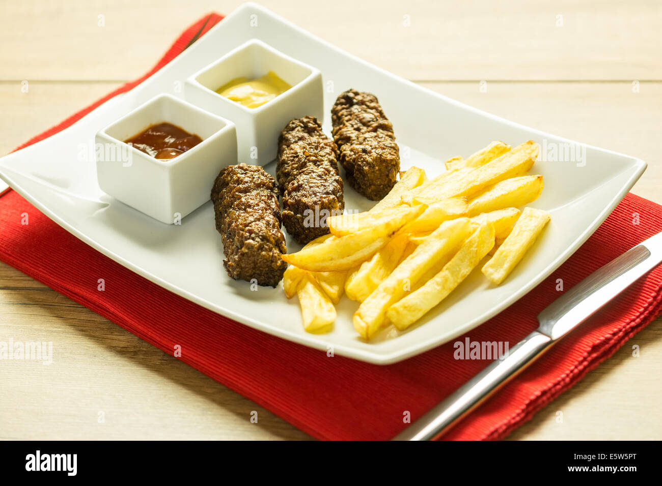 Tradizionale rumena Mici e patate fritte con Ketchup e Senape Close Up Foto Stock