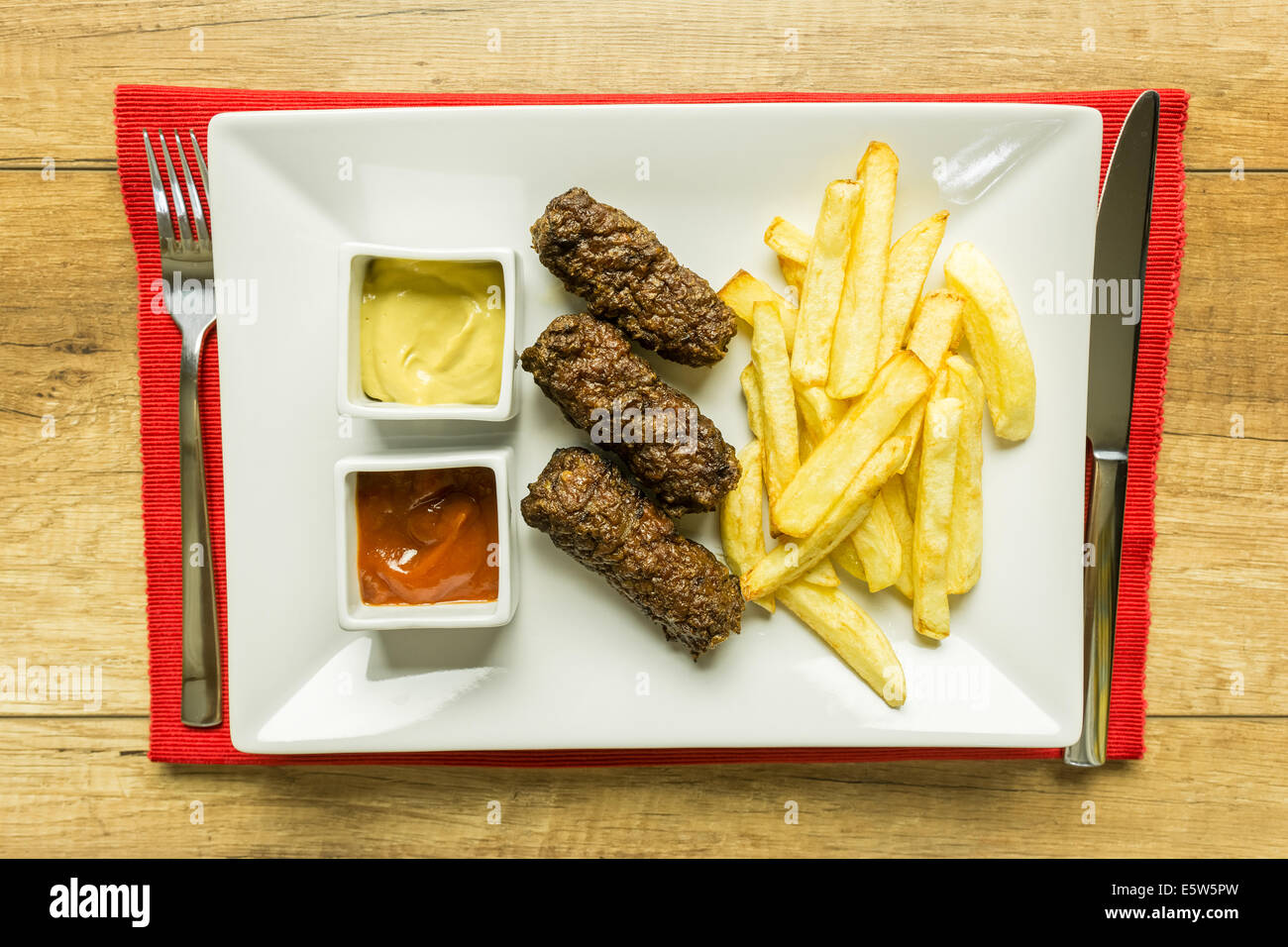 Tradizionale rumena Mici e patate fritte con Ketchup e Senape Close Up Foto Stock