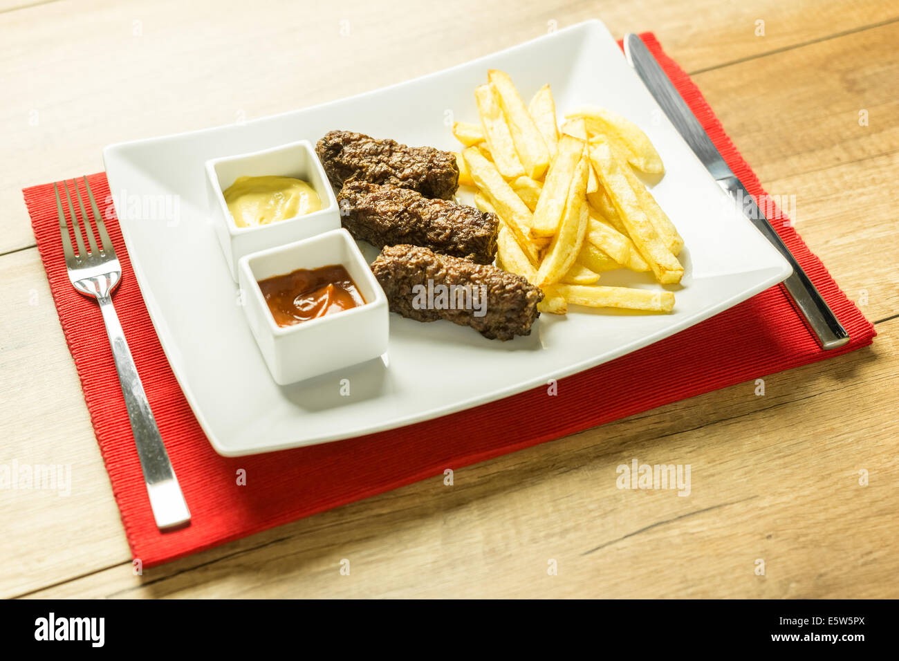 Tradizionale rumena Mici e patate fritte con Ketchup e Senape Close Up Foto Stock