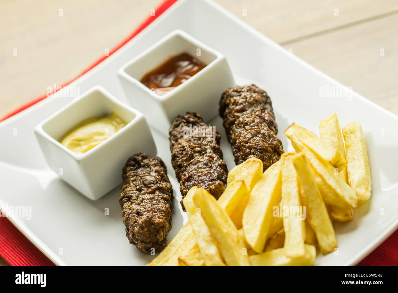 Tradizionale rumena Mici e patate fritte con Ketchup e Senape Close Up Foto Stock