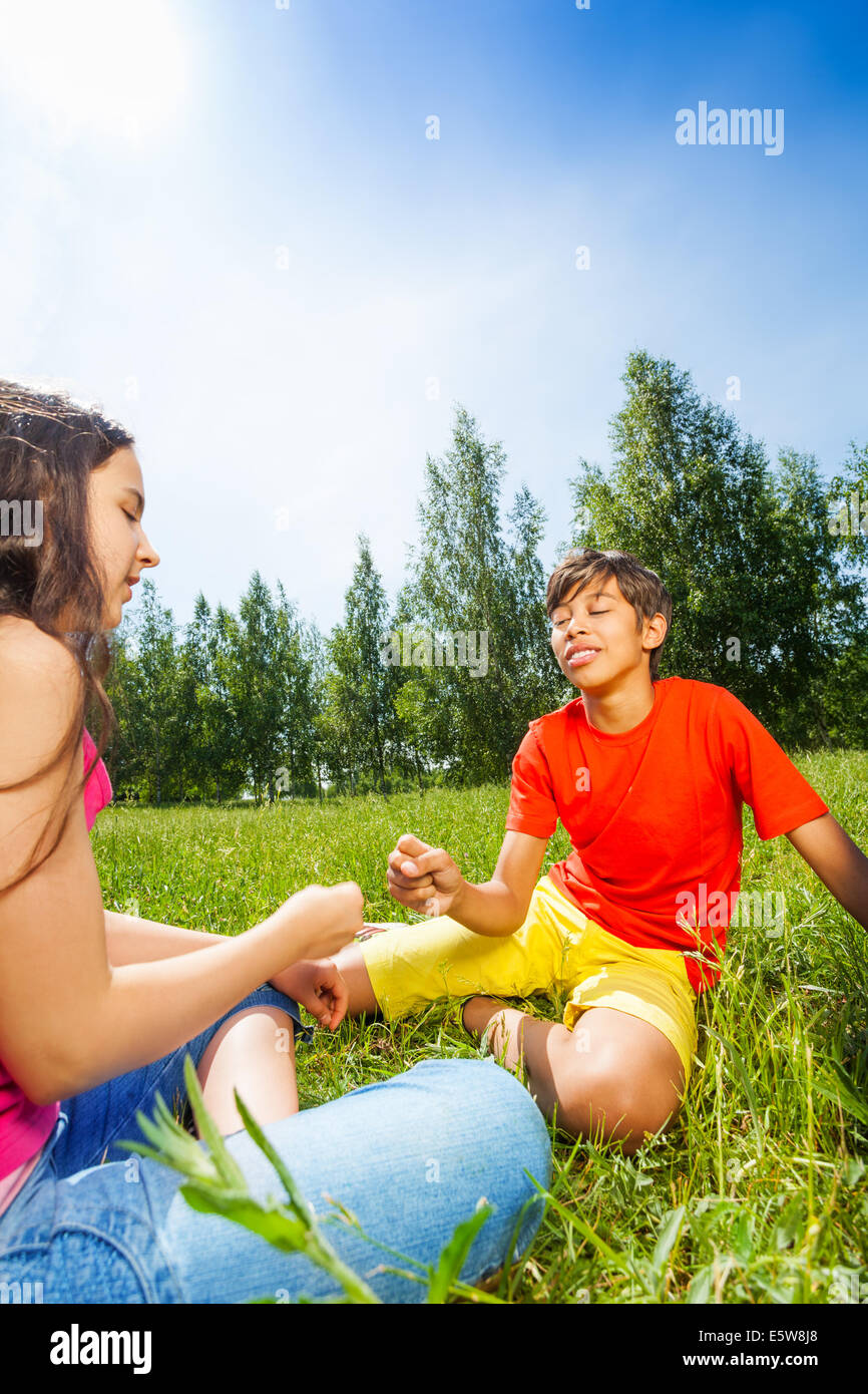 Bambini giocano sasso-carta-forbici sull'erba Foto Stock