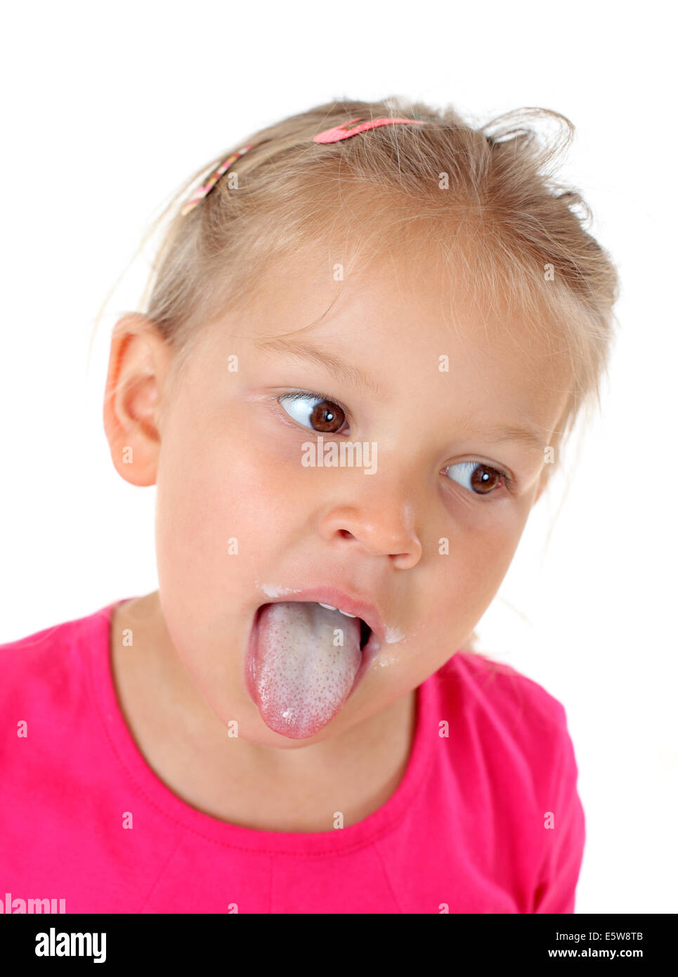 Bambina che mostra la sua linguetta di latte Foto Stock