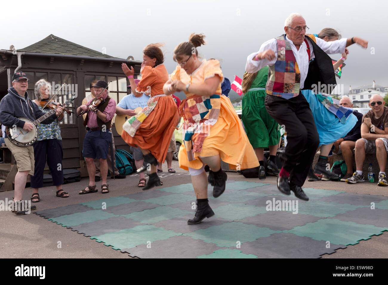 Ballerini Folk eseguire / musicista di strada sul lungomare durante il Sidmouth Folk week 2014. Foto Stock