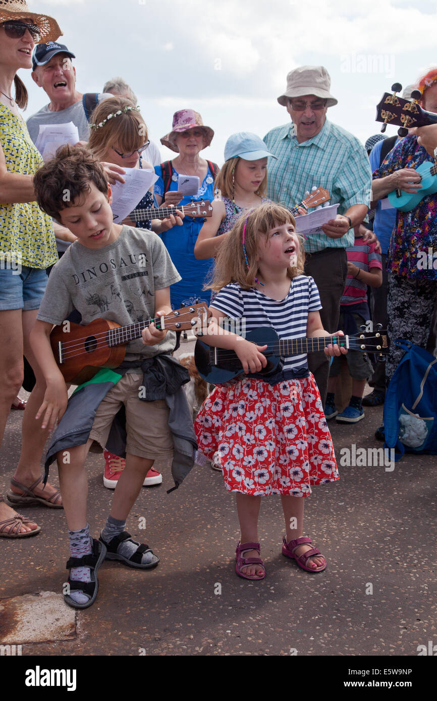 Sidmouth, Devon, Regno Unito. Il 6 agosto, 2014. Musica e Danza al annuale di Musica Folk di Sidmouth settimana. I giovani giocatori in un ukulele gruppo fornire un accompagnamento musicale a un parlare di Sidmouth la Jurassic Coast geologia Credito: Anthony Collins/Alamy Live News Foto Stock Sidmouth, Devon, Regno Unito. Il 6 agosto, 2014. Musica e Danza al annuale di Musica Folk di Sidmouth settimana. I giovani giocatori in un ukulele gruppo fornire un accompagnamento musicale a un parlare di Sidmouth la Jurassic Coast geologia Credito: Anthony Collins/Alamy Live News Foto Stock