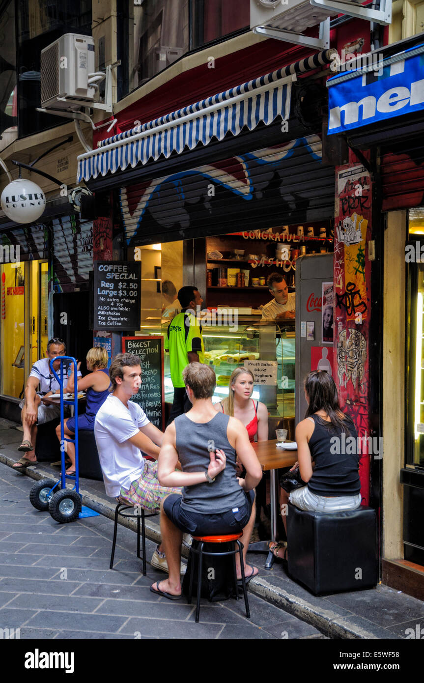Giovani chat al di fuori di un cafe in luogo centrale, uno di Melbourne alla moda laneways. Corsia; corsie vicolo; Australian coffee shop; Melbourne Australia Foto Stock