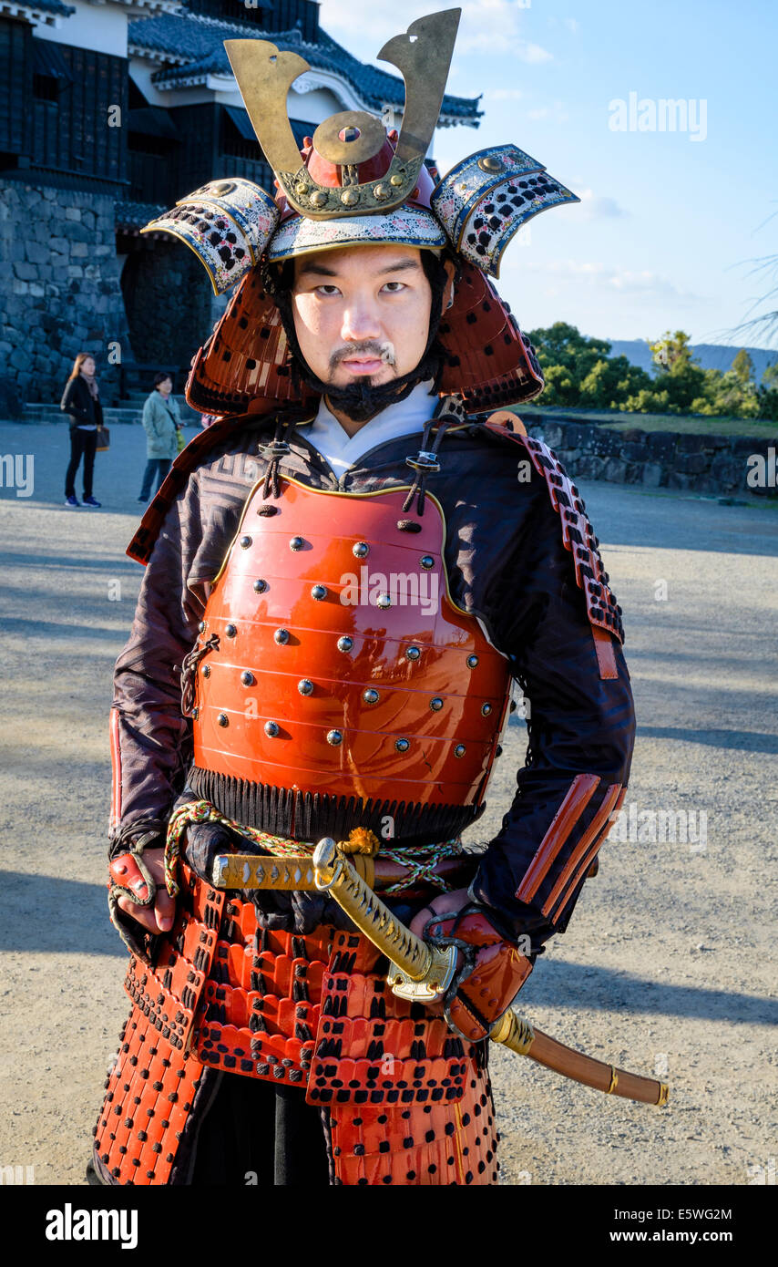 Uomo giapponese indossando il tradizionale samurai armour / armor, compreso elmetto e spade Foto Stock