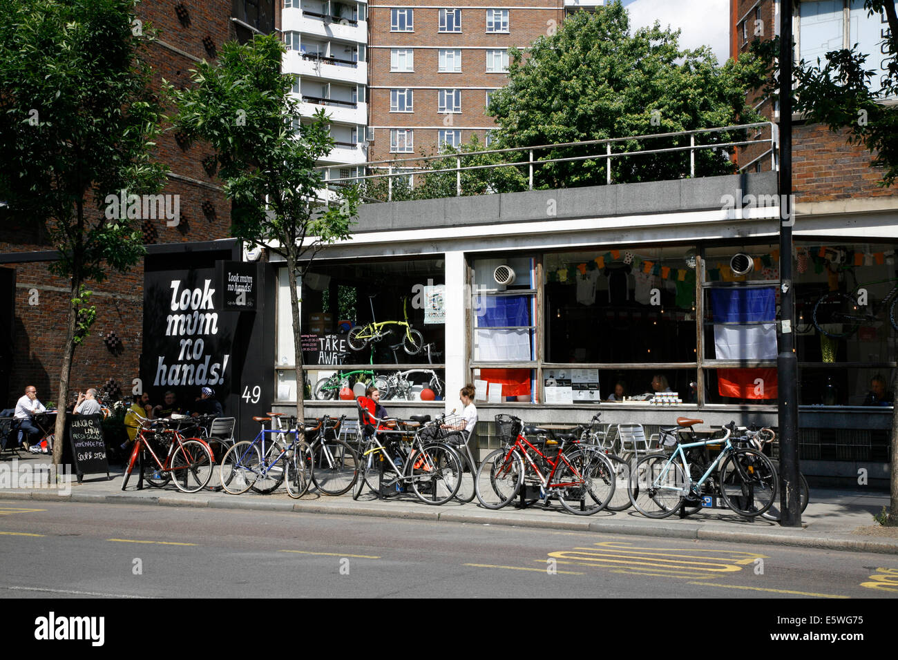 Guarda mamma senza mani cycling shop e caffetteria sulla vecchia strada, St Lukes, London, Regno Unito Foto Stock