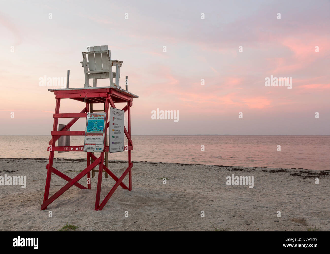 Bagnino di salvataggio stand con sedia su Tampa Bay spiaggia di Fort De Soto county park, Florida, Stati Uniti d'America all'alba Foto Stock