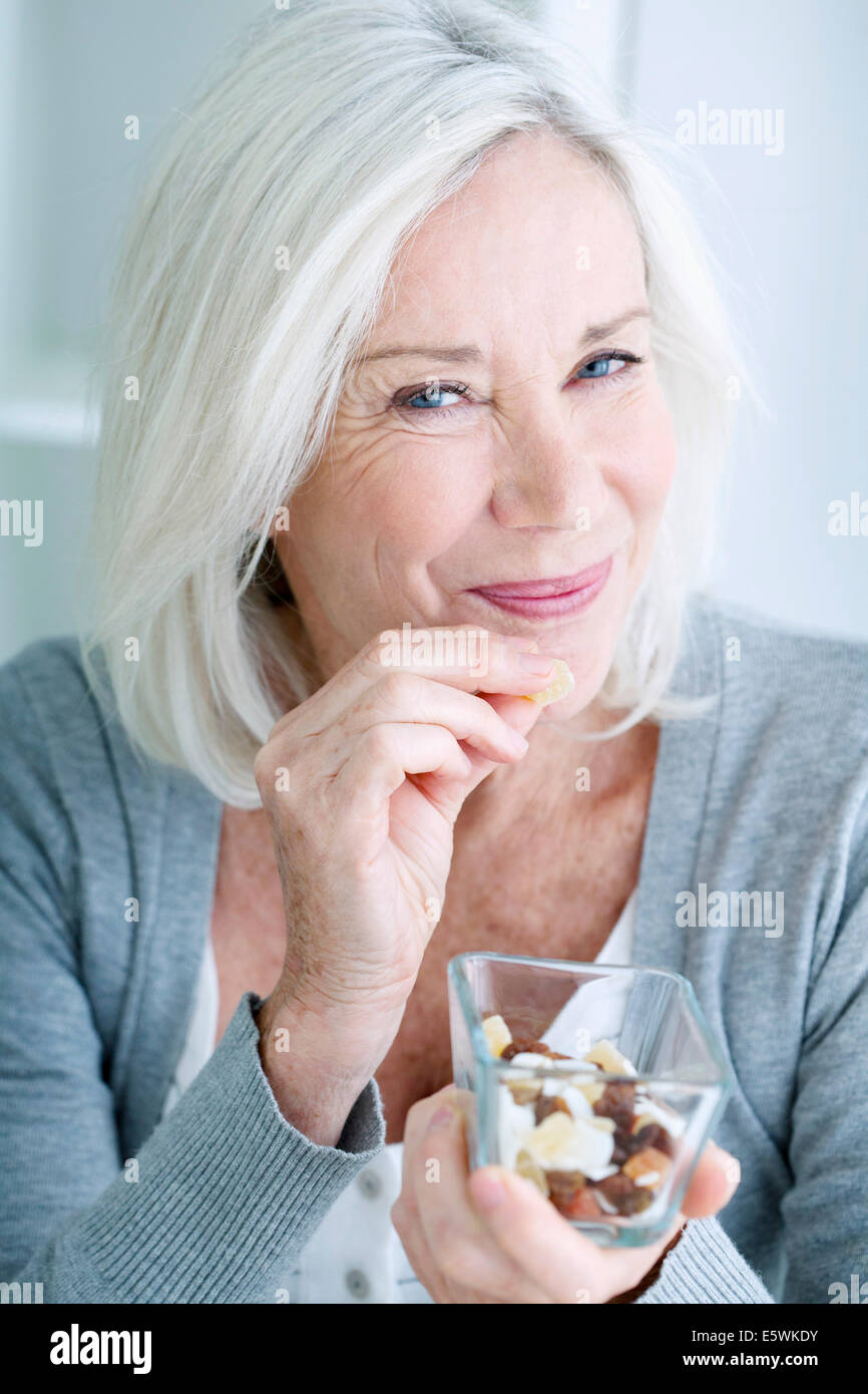 Persona anziana e mangiare la frutta secca Foto Stock