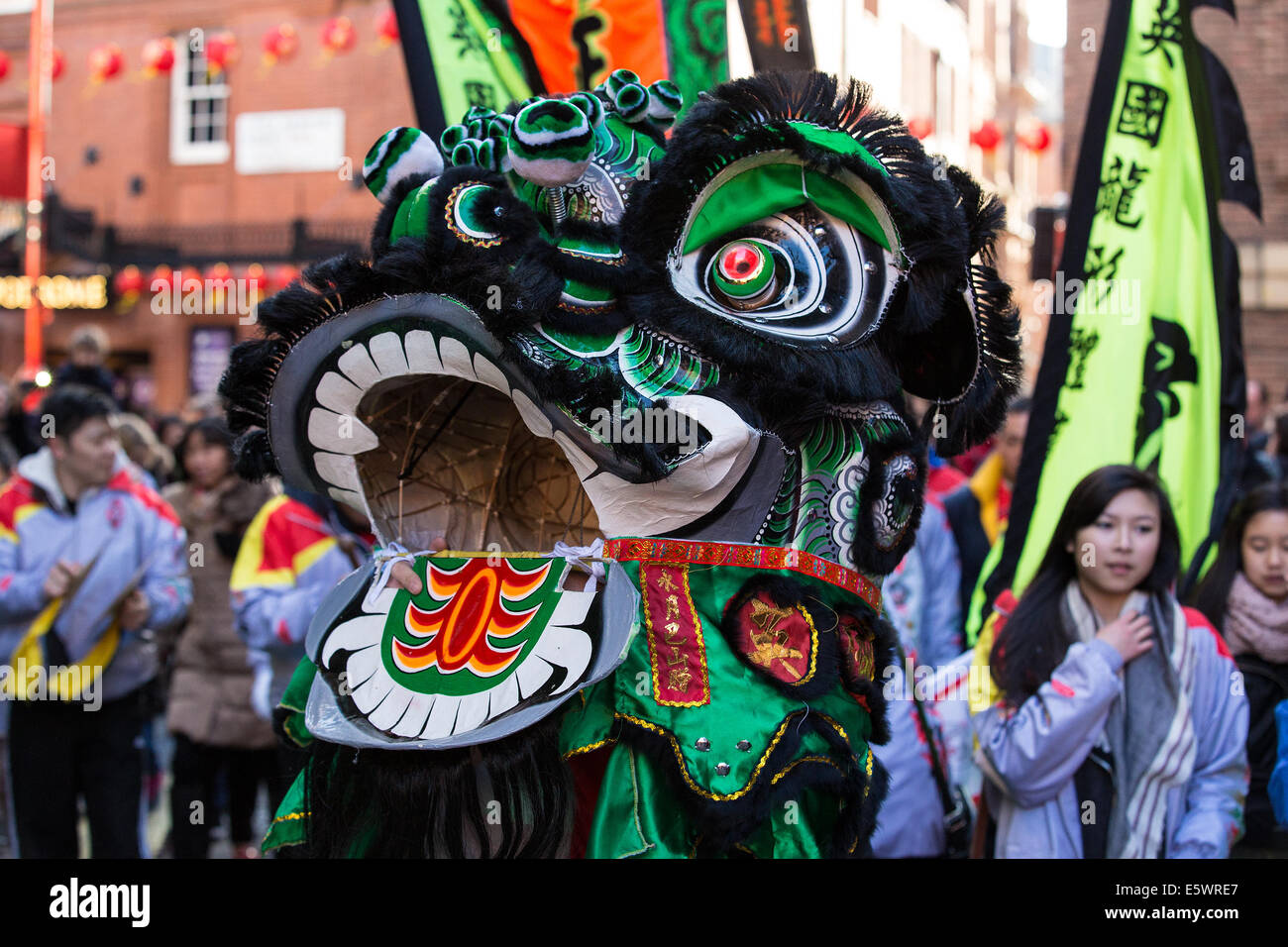 Anno Nuovo Cinese del cavallo inizia a Londra in Chinatown con il tradizionale 'Lion Dance'.La tradizionale cerimonia di 'cai" qing (spiumatura verdi) viene eseguito quando il leone spenna insalata con denaro in buste rosse dangled attaccato dai pali da Foto Stock